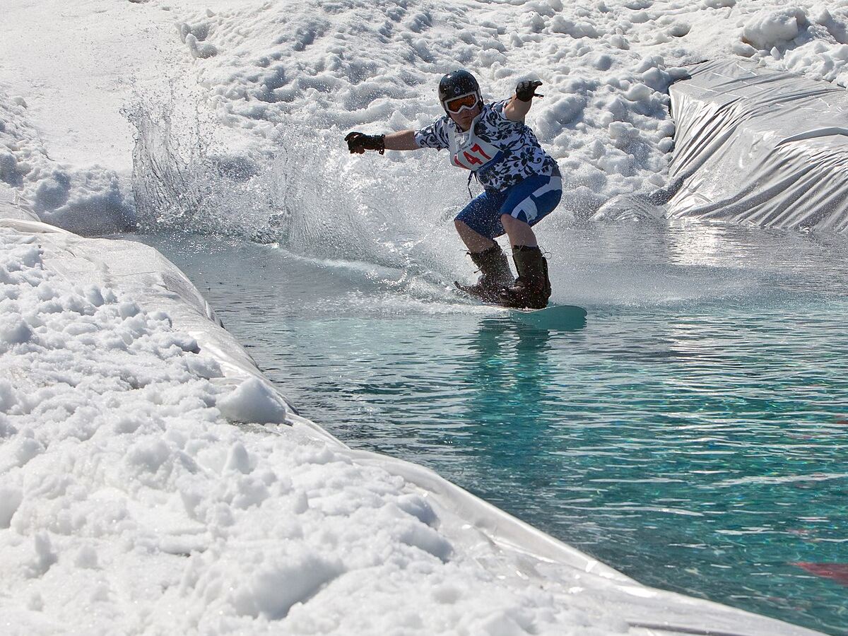 Snowboardeur traversant le bassin d'eau du waterslide (photo d'illustration)